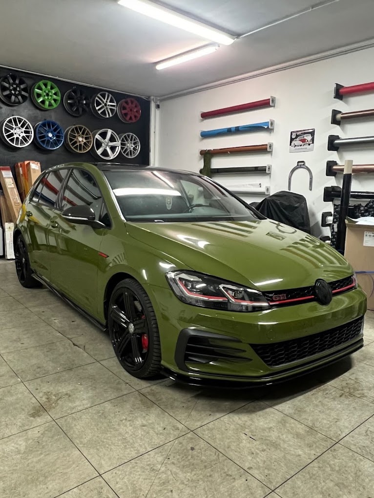 Olivgrüner VW Golf GTI mit glänzender Vollfolierung im Studio von Nato Fahrzeugfolierung